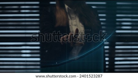 Businesswoman working on holographic financial chart using augmented reality to check economic data. Holographic elements, financial charts, icons and graphs appearing. Finance and money technology.