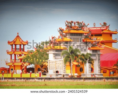 out of focus and blurry photo of chinese temple in malaysia. it is red, yellow and white with chinese architecture