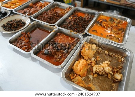 Tegal food stall (Warteg) or Padang food stall. Food stalls that provide various menus such as vegetables, chicken curry sauce, beef, eggs, tofu, tempeh. Asian or asia food.  Royalty-Free Stock Photo #2401524907