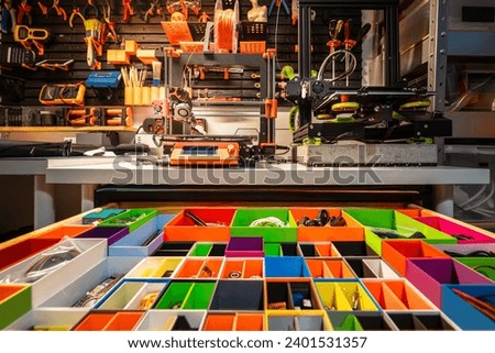 Drawer with colorful compartments for parts. Home workshop. Wall with tools. 3d printers.