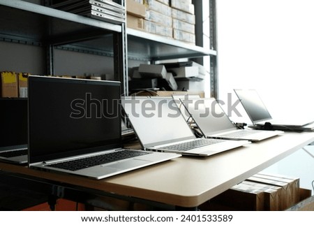 Row of laptops being prepared and set up for new employees in a company Royalty-Free Stock Photo #2401533589