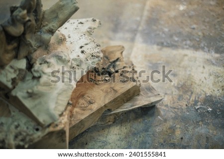 The striking arrangement of burl wood, with its wild patterns and forms, creates a visual poetry in wood, hinting at the artisanal journey ahead. Royalty-Free Stock Photo #2401555841