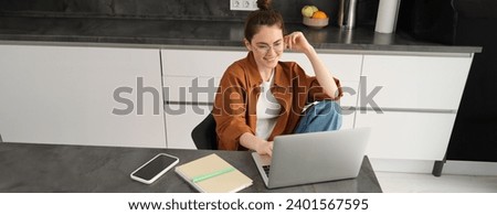 Top view of young student, woman in glasses, sitting at home with laptop, studying, doing homework or joining online course lesson from computer.