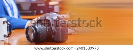 A businessman working with a cup of tea and camera.