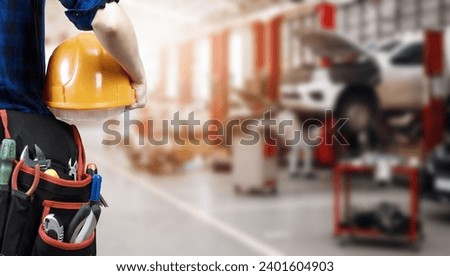 Car Mechanic in Car Repairing garage and Car repairing shop Stock image. Car mechanic with holding tools background hd stock image. Royalty-Free Stock Photo #2401604903