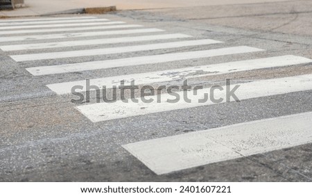 city crosswalk with pedestrians crossing road, traffic signals, and buildings in background