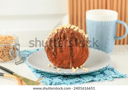 Cromboloni, Croissant Bomboloni. Round New York Roll with Chocolate Sauce and White Chips Royalty-Free Stock Photo #2401616651