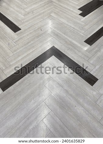 High angle view of a herringbone parquet floor with a striking chevron pattern of light and dark wood planks, ideal for modern interior design backgrounds.