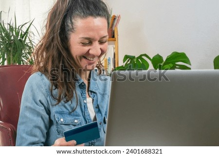 Banking Connection: Photograph of a Smiling Adult Woman with her Computer and Bank Card, Copy Space in Financial Technology
