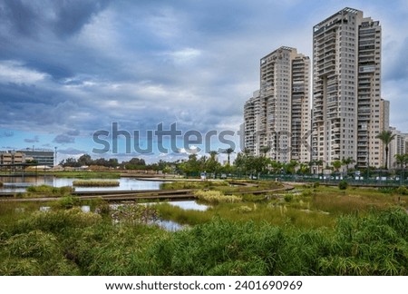 Landscape of pond in the park over residential buildings. Petah Tikva, Israel.