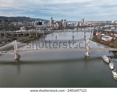 Aerial shot of Tilikum Crossing bridge, other bridges and skyline in Portland, Oregon late November on an overcast, cloudy day.