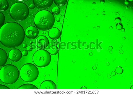 Green drops of oil or serum texture background. Oil drops on the water's surface. Macro photography	 Royalty-Free Stock Photo #2401721639