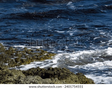 Sea with waves and rocks on the shore Royalty-Free Stock Photo #2401754551