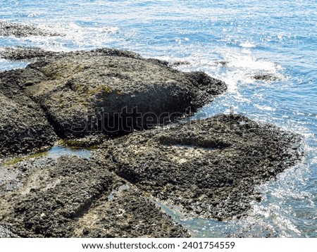Sea with waves and rocks on the shore Royalty-Free Stock Photo #2401754559