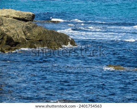 Sea with waves and rocks on the shore Royalty-Free Stock Photo #2401754563