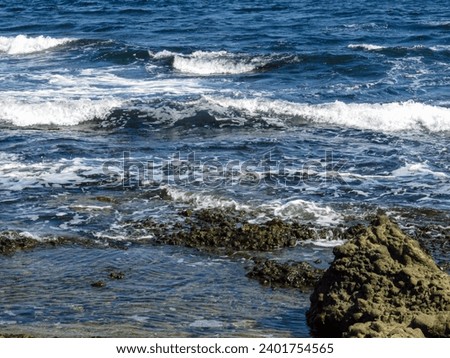 Sea with waves and rocks on the shore Royalty-Free Stock Photo #2401754565
