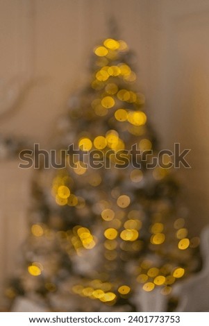 A blurred Christmas tree in the lights of a garland