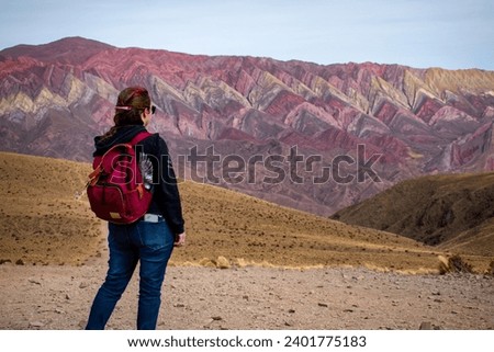 Tourist exploring Argentina. Young woman enjoying the views in El Hornocal, Jujuy, Argentina. Alone person on vacation in the north of Argentina. Tourist touring El Hornocal in Argentina.  Royalty-Free Stock Photo #2401775183