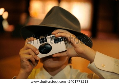 close up of child with vintage throwaway film camera at wedding  Royalty-Free Stock Photo #2401778213