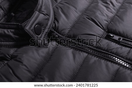 Closeup of black zipper on a wintry black jacket.Zipper winter jacket, close-up.Quilted jacket.