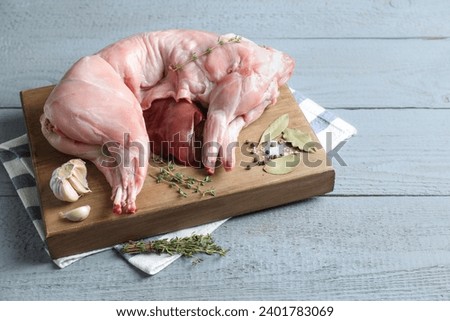 Whole raw rabbit, liver and spices on grey wooden table, space for text