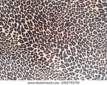 Picture of a collared shirt with a small brown tiger pattern.
