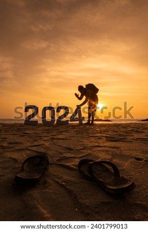 Happy New Year 2024 creative photography, Young man with 2024 numbers at beach during sunset