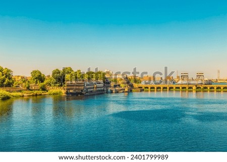 Cruise ships pass through the Esna lock. Water gate on the Nile River connecting Luxor and Aswan. Esna, Egypt - October 20, 2023. Royalty-Free Stock Photo #2401799989