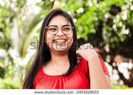 Latin american cheerful woman smiling wearing braces outdoor Royalty-Free Stock Photo #2401820033