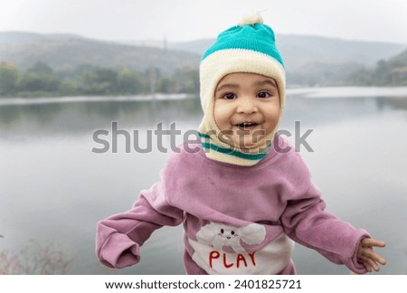 cute infant in winter dress and monkey cap innocent facial expression at morning image is taken at Jagdish Temple udaipur rajasthan india.
