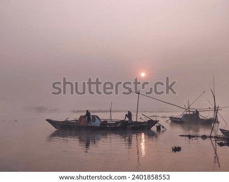 This is a picture of a fishing boat in winter morning from Bangladesh. This is a normal traditional fishing boat. They are preparing for hunting fish.
