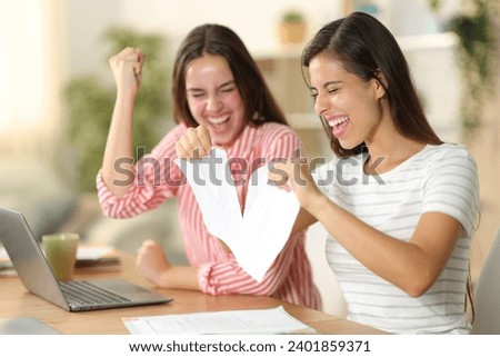 Two happy tele workers breaking contract celebrating at home Royalty-Free Stock Photo #2401859371