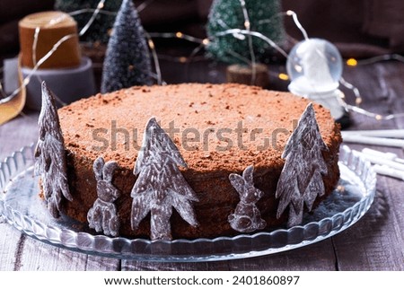Chocolate honey cake in a Christmas decoration on a wooden background.