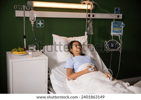 Portrait of happy African girl lays on bed inhospital ward. Royalty-Free Stock Photo #2401863149
