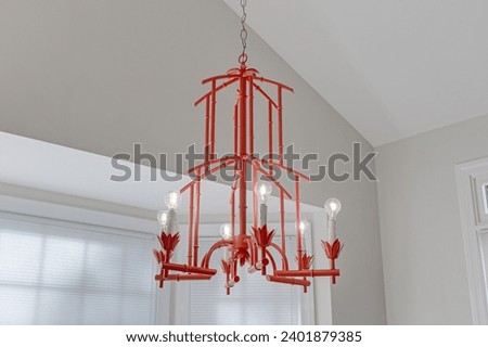 Vibrant Red Pagoda-Style Chandelier Lighting Fixture Suspended in a Room with Neutral Tones and Crown Molding for Stylish Interior Decor Royalty-Free Stock Photo #2401879385