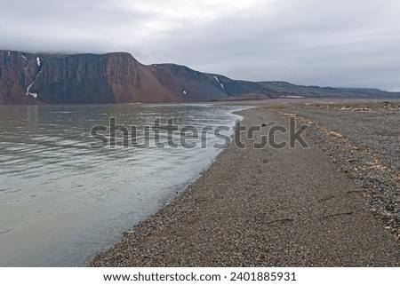 Quiet Gravel Beach on the High Arctic on Lomfjorden in the Svalbard Islands Royalty-Free Stock Photo #2401885931