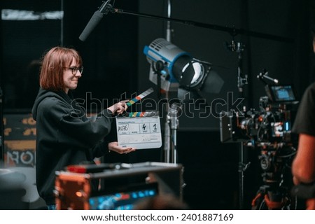 Assistant director with clapperboard on set. Close-up of firecrackers for filming a movie, advertising, TV series. Modern photography technique. Royalty-Free Stock Photo #2401887169
