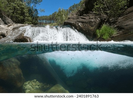 Waterfall on a wild stream, split level view over and under water surface, natural scene, Spain, Galicia, Pontevedra province