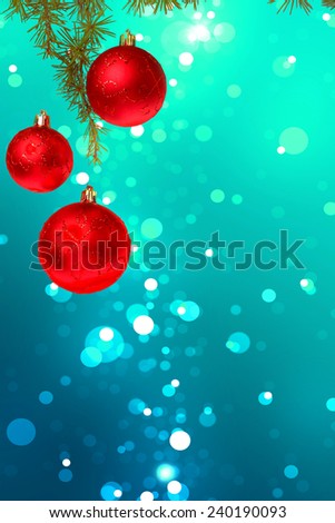 Christmas red balls with green fir tree on colorful blue bokeh background. New Year greeting card. Xmas Decorations. Sparkles and bokeh. Shiny and glowing copyspace, place for text and advert.