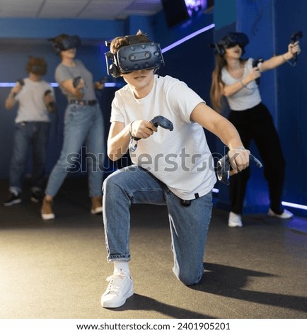 while playing virtual shooter, guy got down on one knee and actively manipulated joysticks. future technologies. Slow Motion 8k RED Royalty-Free Stock Photo #2401905201