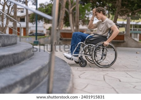 Angry disabled man with wheelchair with architectonic barriers in the city unable to going up stairs Royalty-Free Stock Photo #2401915831