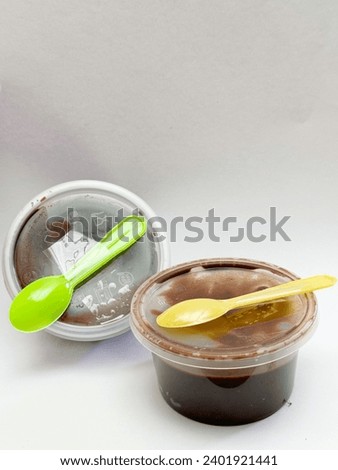 Chocolate cake in a small container with cute colorful spoons interactive focus