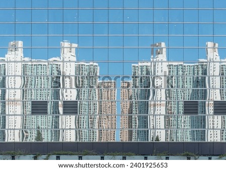 Reflection of high rise residential building of public estate on modern architecture in Hong Kong city