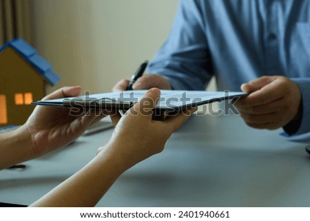 Accountant's hand receiving business documents and Signing  business contract Signing to approve contracts or business partnerships, warranty documents and financial agreements, document verification