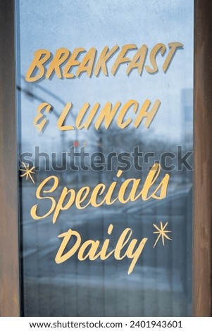 A window sign that reads "Breakfast and Lunch Specials Daily," enticing passersby with a tempting array of culinary delights at this restaurant.