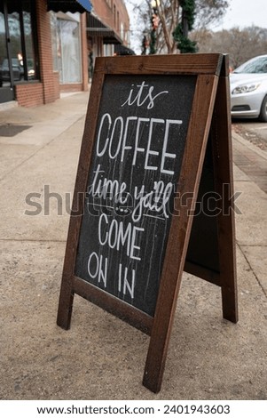 Clover, South Carolina, United States, 16 Dec 2023: A charming sidewalk sign warmly declares, "It's coffee time, ya'll come in!" 