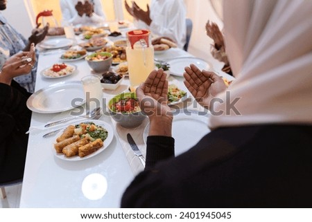 In the sacred month of Ramadan, a diverse Muslim family comes together in spiritual unity, fervently praying to God before breaking their fast, capturing a moment of collective devotion, cultural Royalty-Free Stock Photo #2401945045