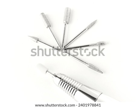 Electric nail drill for manicure and pedicure with bits on a white background  Royalty-Free Stock Photo #2401978841