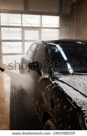Contactless car wash self service system. Washing dirty car in car wash station with foam