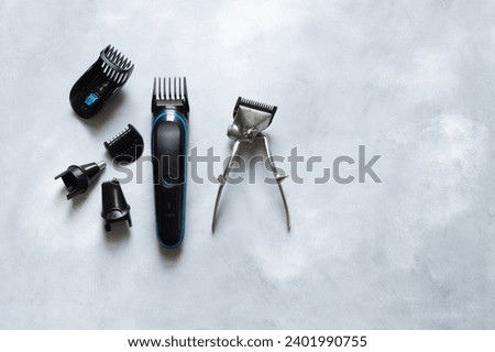 Old and new hair clipper and shaving supplies on white rustic background, barber accessories Royalty-Free Stock Photo #2401990755